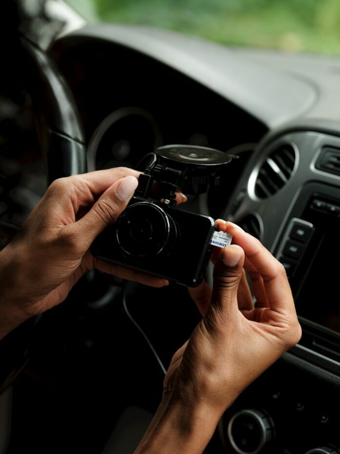 A person holding a camera in a car