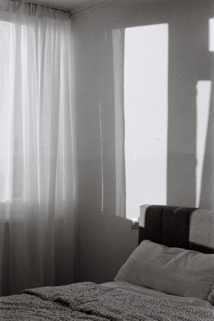 A bed sitting in a bedroom next to a window