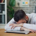 만성피로, 일상 속에서 지친 몸과 마음을 다독이는 방법 a man sitting at a desk with his head in his hands