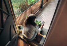 만성피로, ‘느리게 살아보기’가 해답일까?…실천 가능한 일상 회복 루틴 주목 Woman sitting on balcony with smartphone