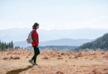 일상의 ‘걷기 습관’이 바꾸는 건강 트렌드…실천 루틴으로 만드는 방법 a man with a backpack walking across a dry grass covered field
