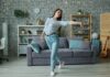 늘어나는 집콕 생활, 건강 지키는 ‘홈 웰니스’ 습관이 뜬다 Young woman dancing in a modern living room.