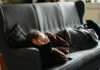“끊이지 않는 피로, 나만의 루틴 찾기가 핵심” woman in pink jacket lying on gray couch
